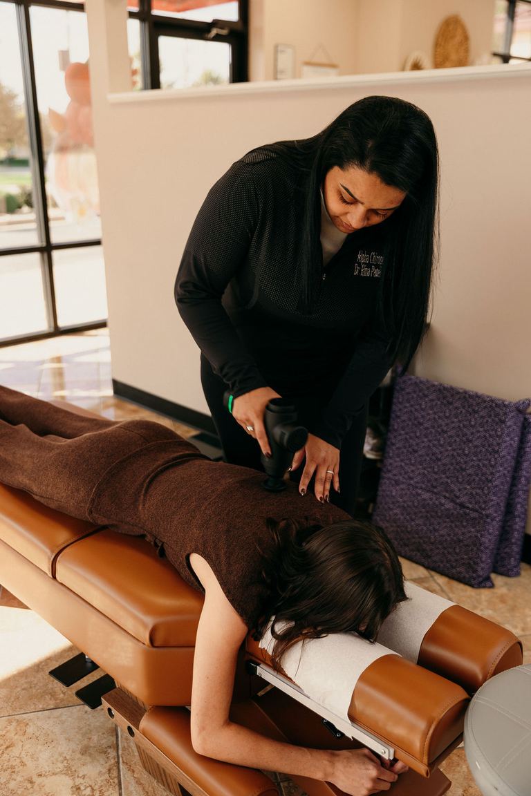 Dr. Rina Patel-Jerls adjusting a patient on the treatment table at Alpha Chiropractic